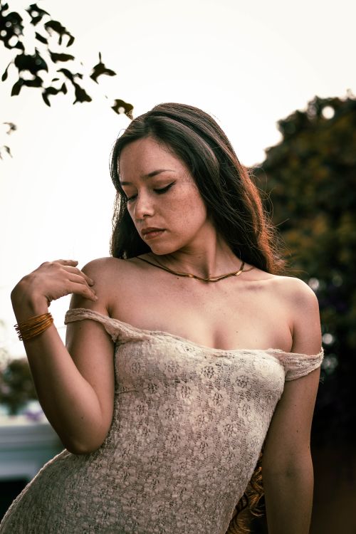 Free Beautiful woman in a stylish dress posing elegantly outdoors during summer Stock Photo