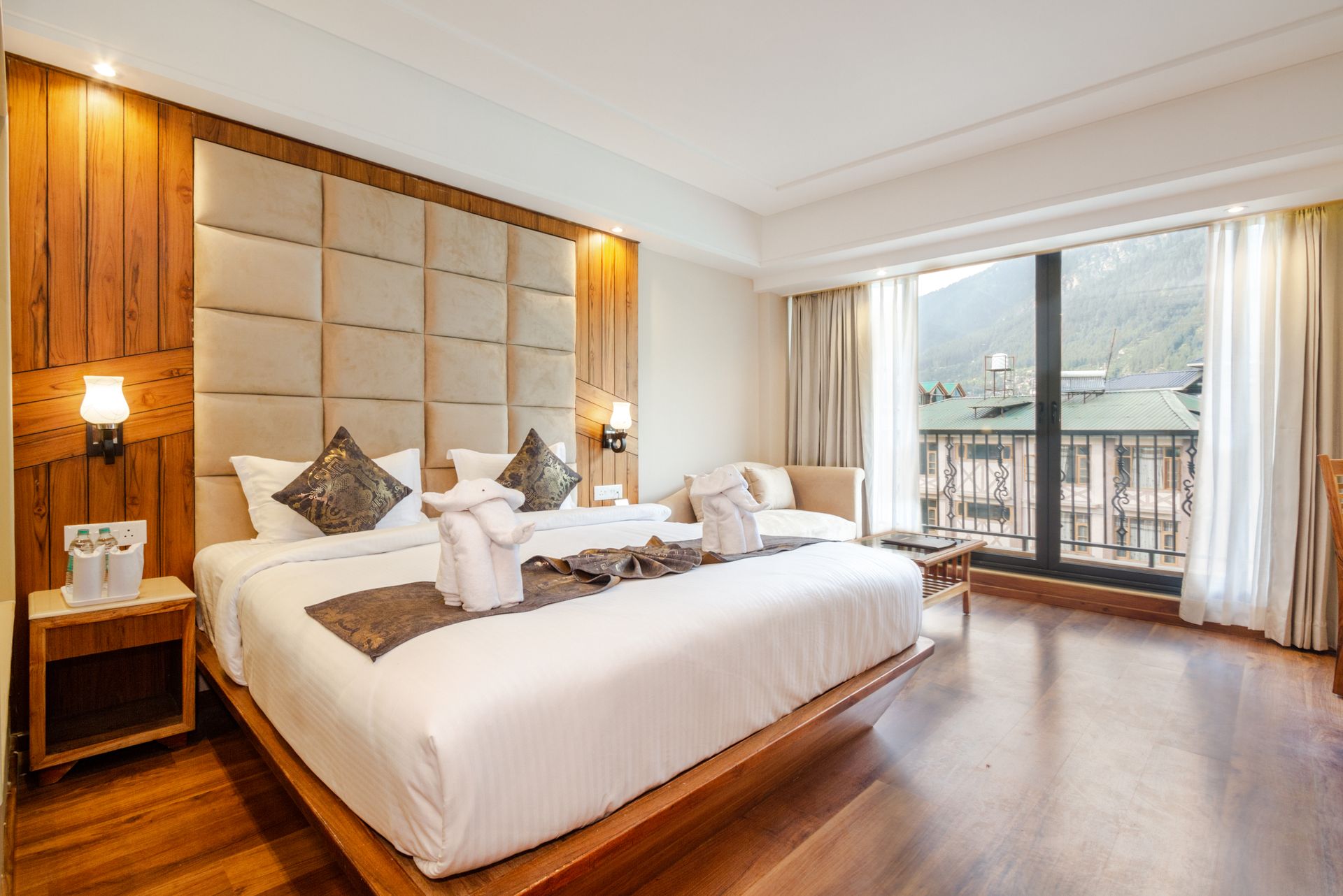 A hotel room with wooden floors and a large bed