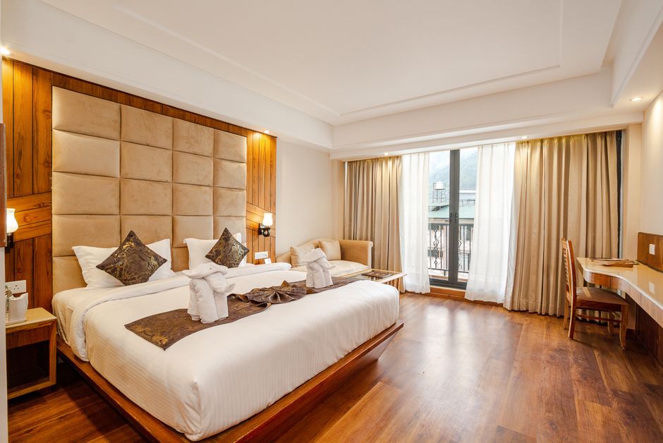 Spacious and elegant hotel room with a king-size bed and large window view.