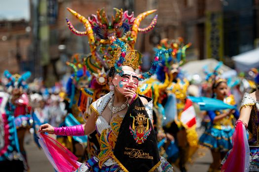 Colorful costumes and masks at a traditional festival parade in Puno, Perú, celebrating cultural heritage.