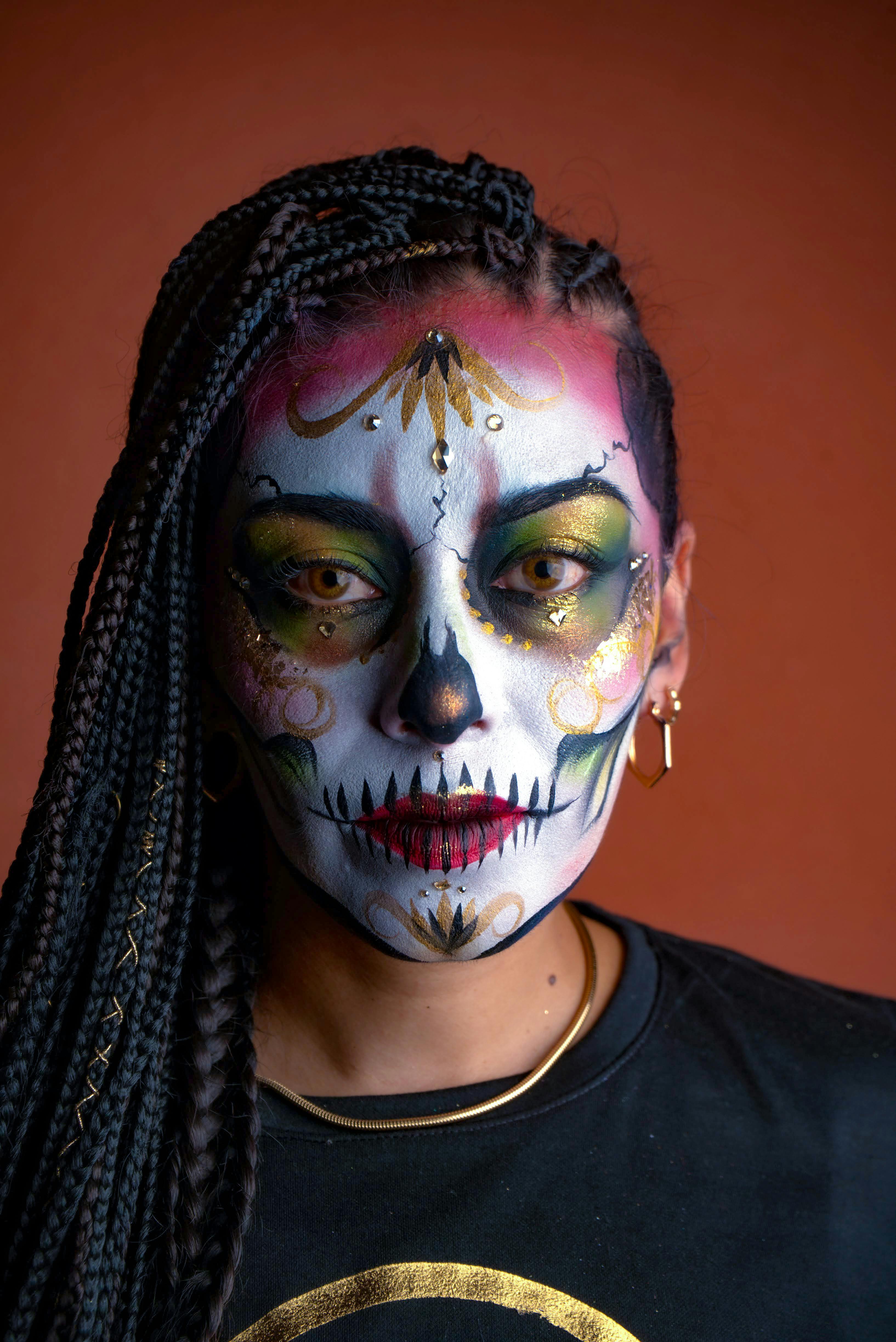 a woman with a skull face paint and dreadlocks