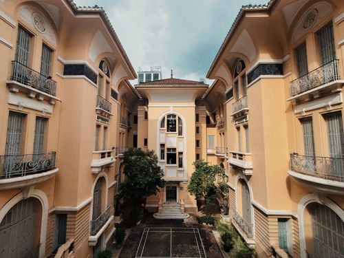 Free Stunning view of urban courtyard framed by elegant yellow townhouses. Stock Photo