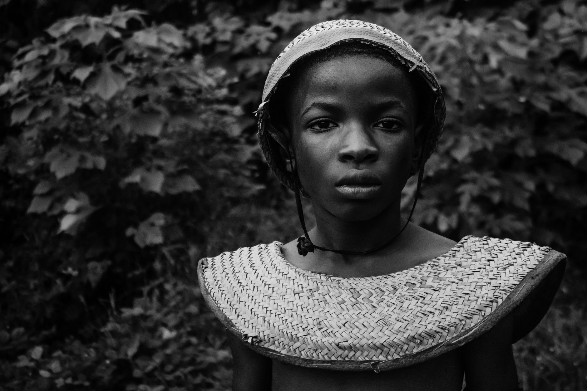 Captivating black and white portrait of an African teenager wearing traditional attire.