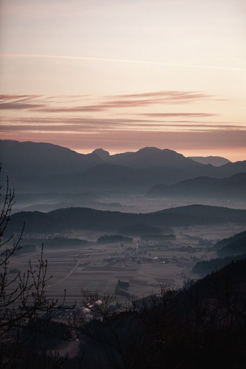 Free Serene mountain valley at dawn with misty hills and a tranquil sky. Stock Photo