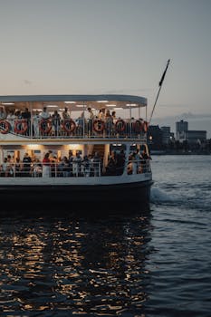 A scenic view of a crowded ferry on the Bosphorus in Istanbul at dusk, with cityscape background.
