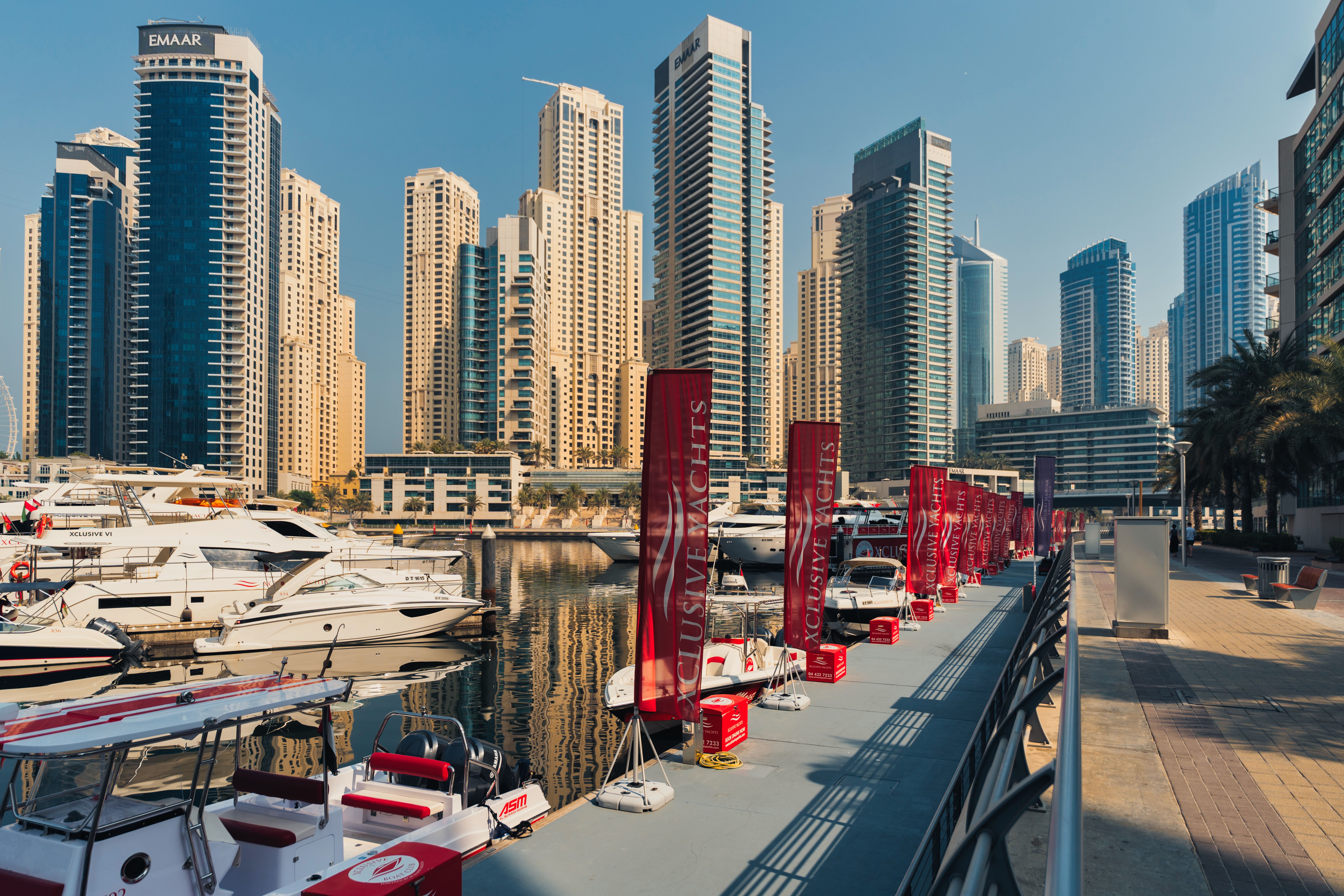 Vibrant view of Dubai Marina featuring luxury yachts and towering skyscrapers under bright daylight.