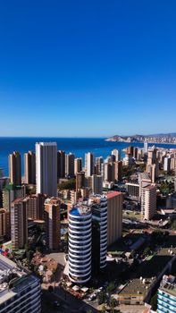 Stunning aerial view of Benidorm's modern skyline against the serene coastline on a bright day.