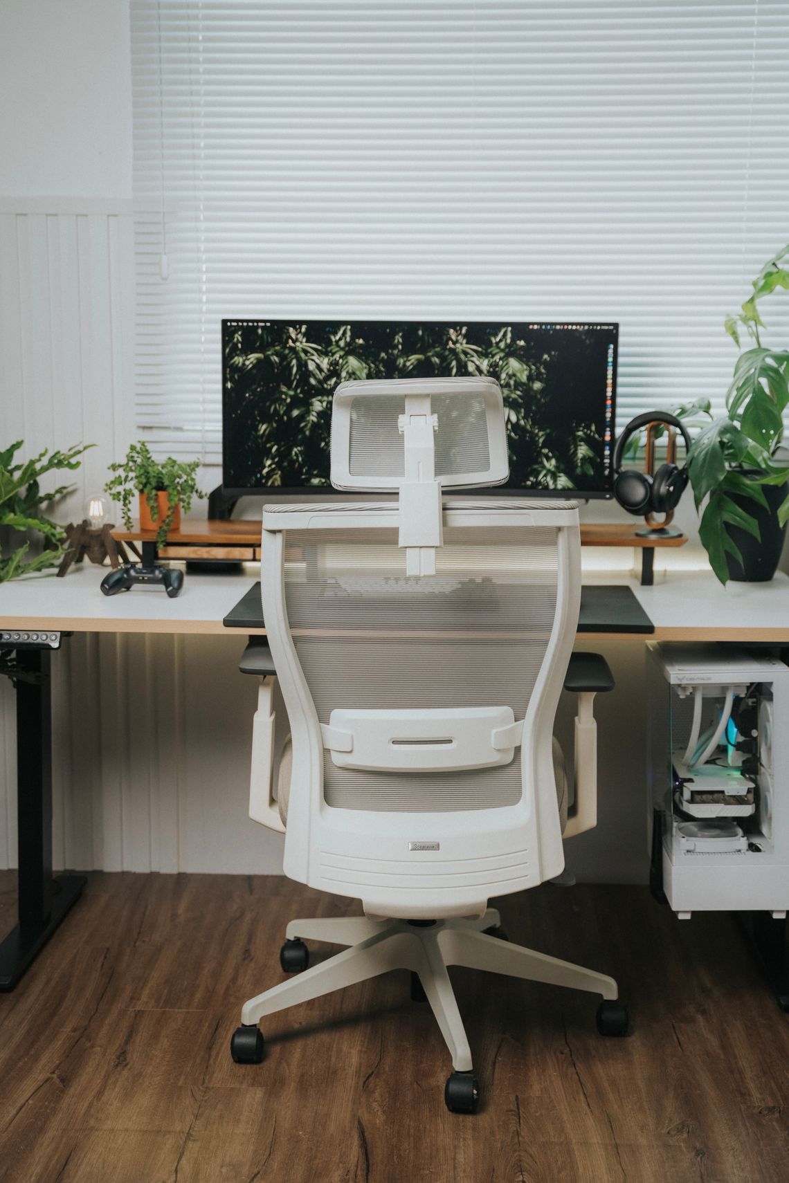 White ergonomic office chair beside a modern desk and large monitor