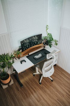 Ergonomic home office with a gaming setup and lush greenery, showcasing a stylish and functional design.