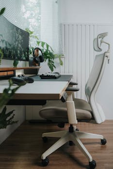 Sleek home office with ergonomic chair, monitor, and indoor plants for a stylish workspace.