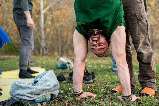 Man performing an inverted yoga pose during an outdoor session.
