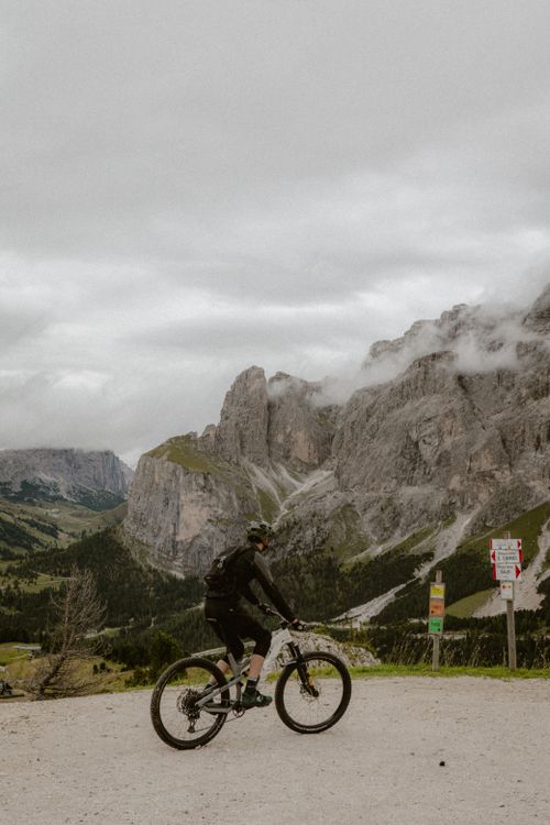 Free A cyclist navigates a picturesque mountain trail under an overcast sky. Stock Photo