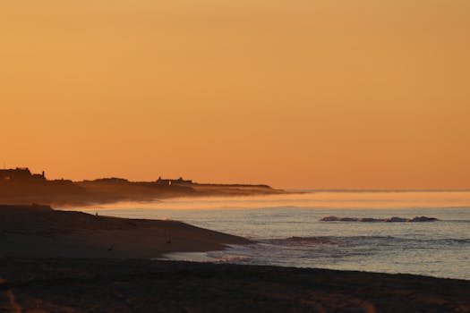 Peaceful coastal scene at Nantucket during sunrise with misty waves.