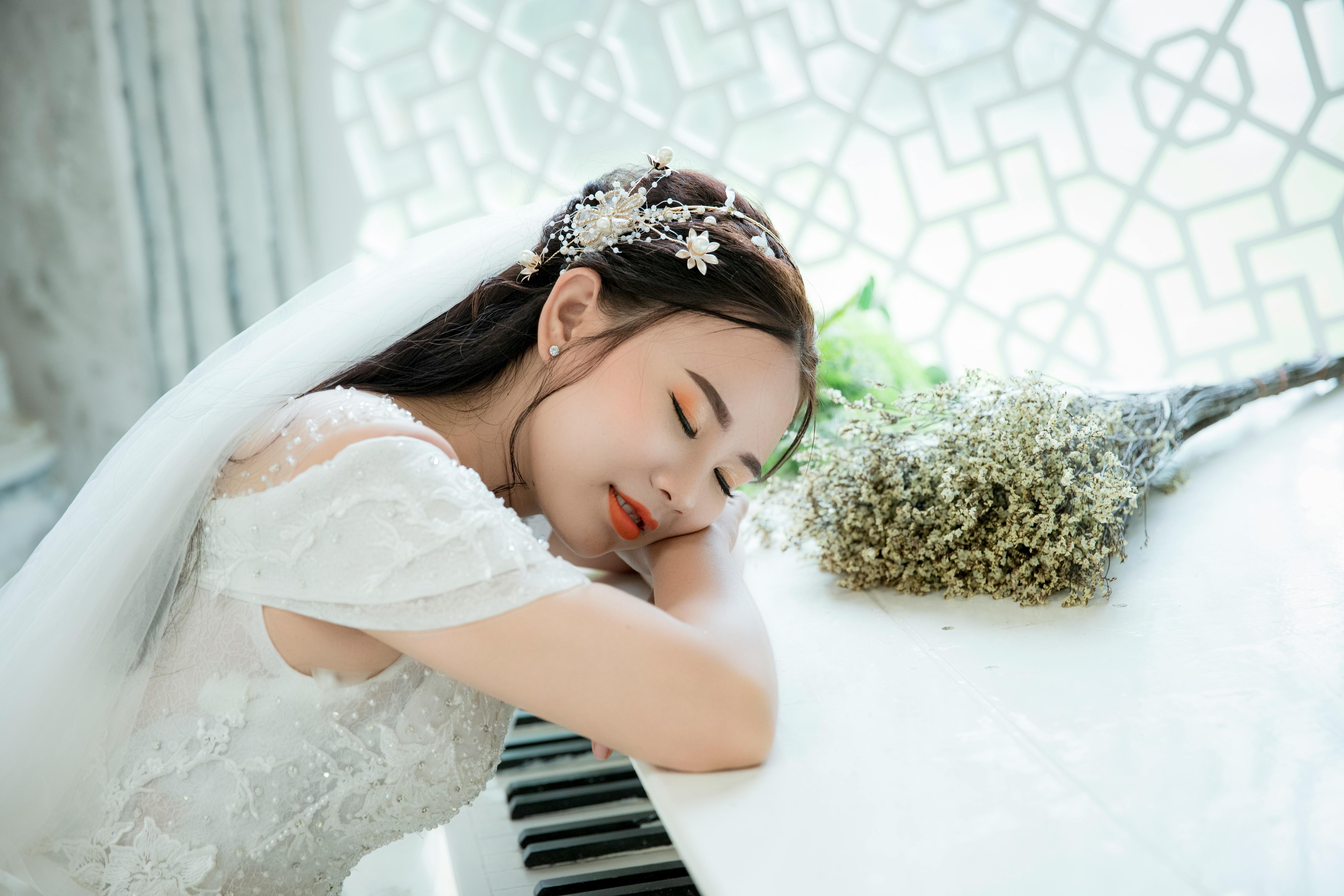 photo of woman taking a nap on top of piano