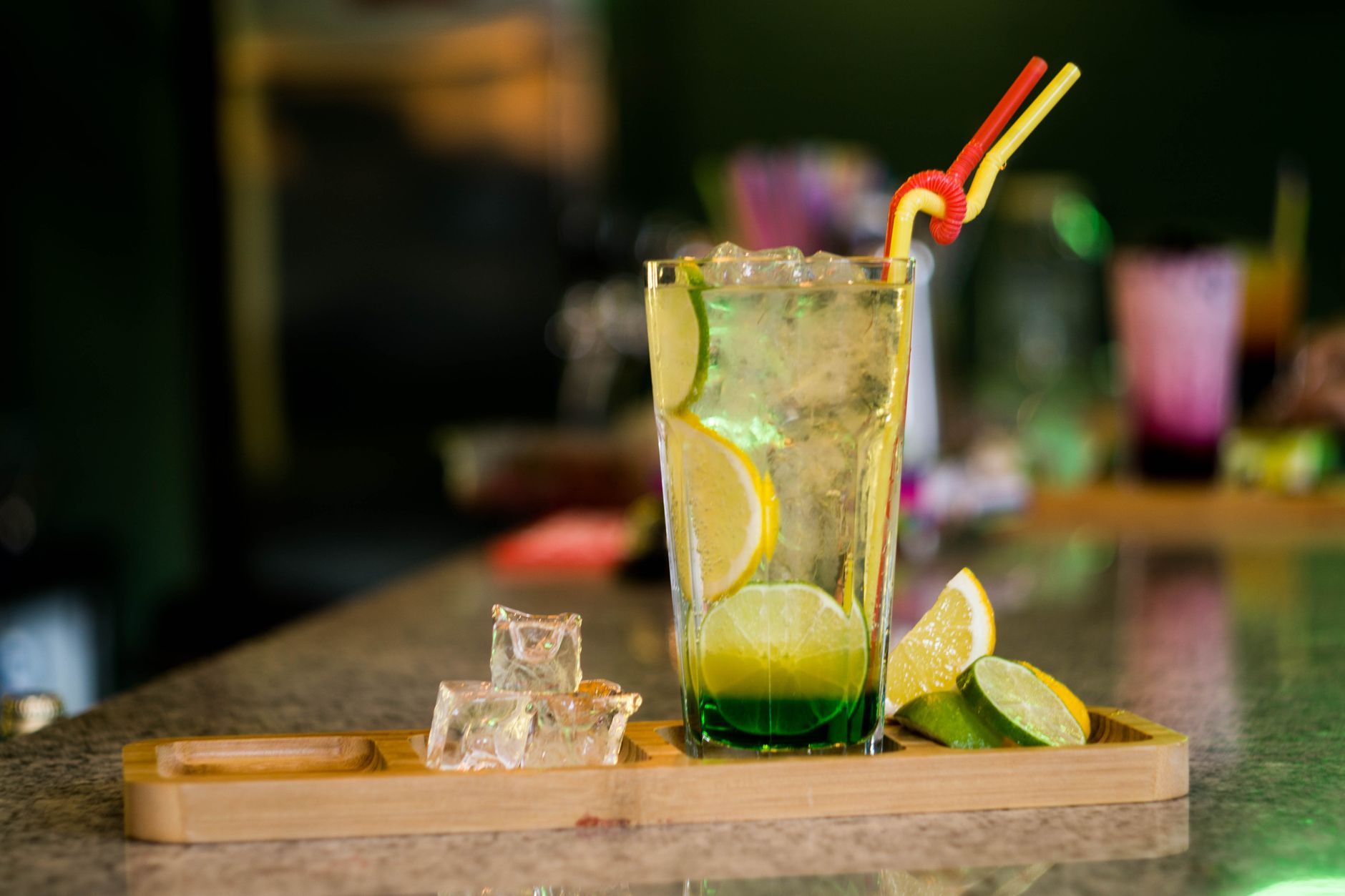 A crystal highball glass filled with whisky and ice, garnished with a citrus twist.