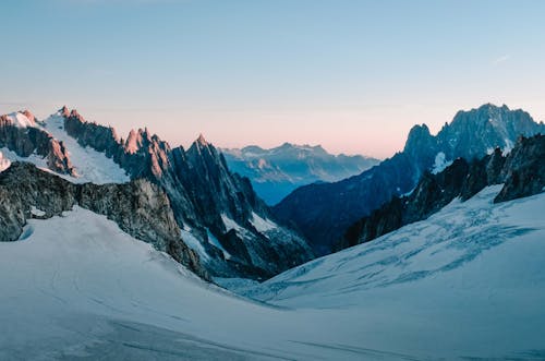 Free Serene view of snow-capped mountains at sunrise, capturing the tranquility of the French Alps. Stock Photo