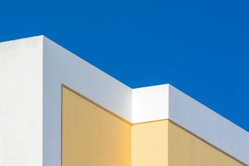 Free Simple architectural design with bold colors and clear blue sky, embodying modern minimalist style. Stock Photo