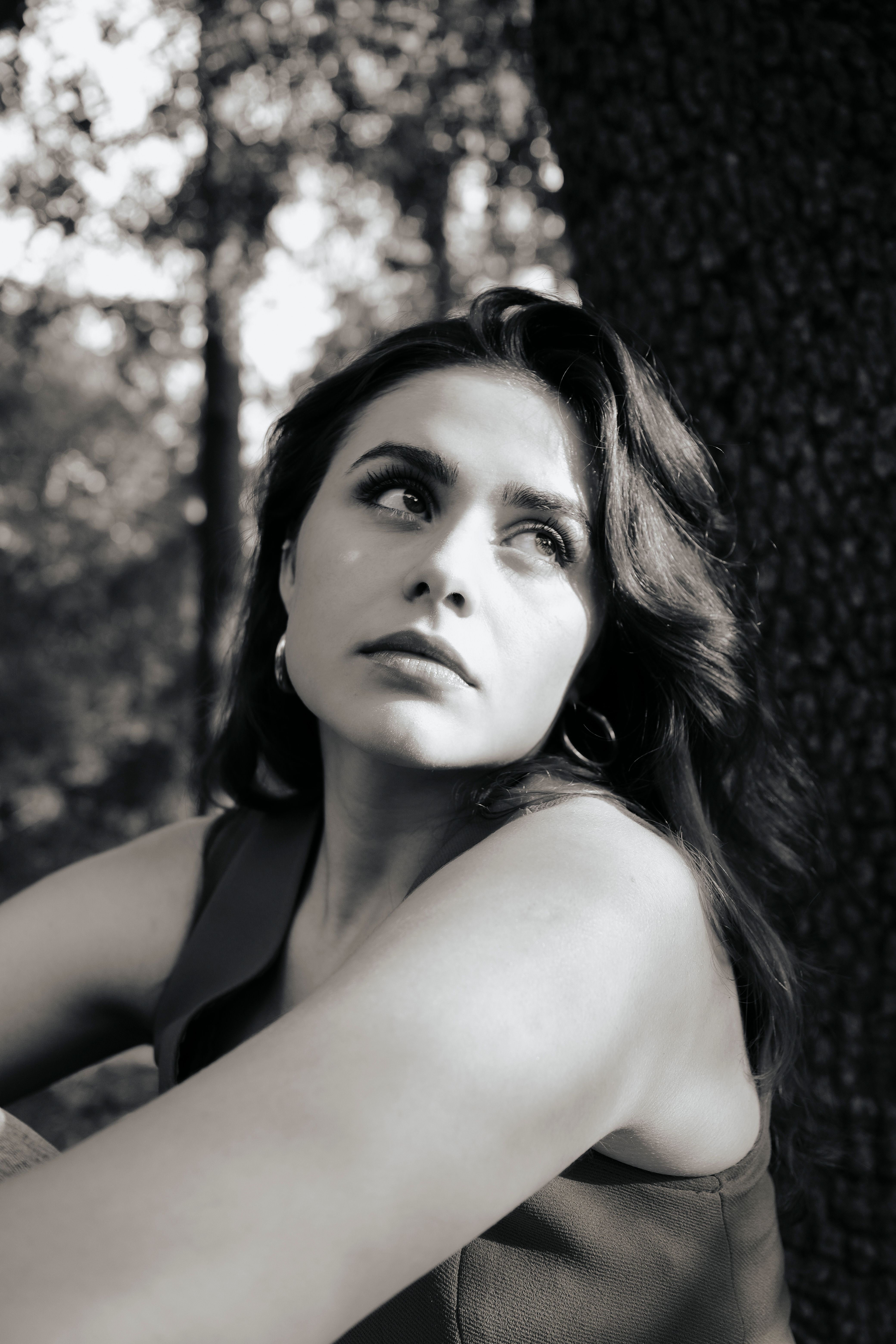 A woman is sitting in front of a tree · Free Stock Photo