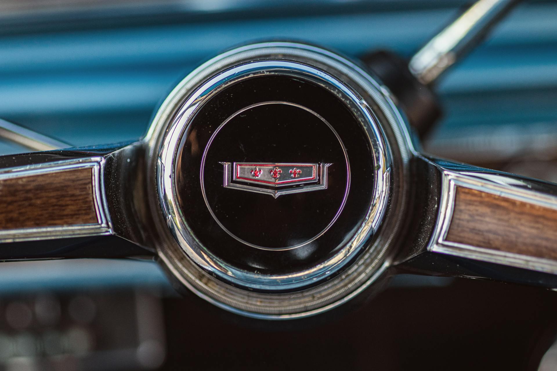 Close-up of a vintage Chevrolet Caprice steering wheel featuring logo and wood trim detail.