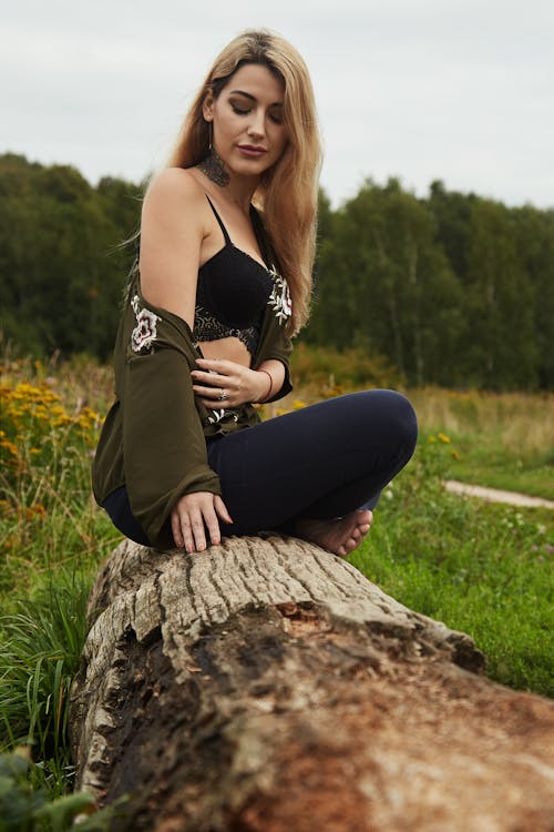 무료 나무 통나무에 앉아있는 여자의 사진 스톡 사진