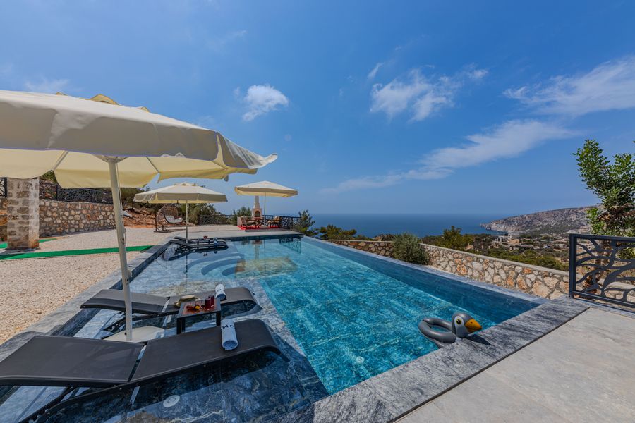 Piscine longue, parasols ivoire et ciel clair