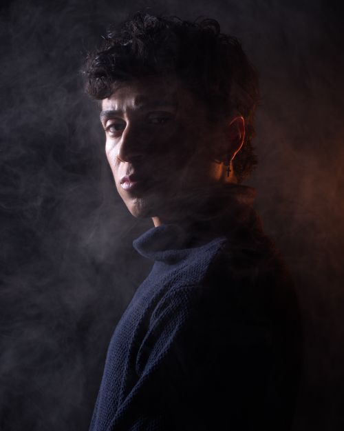 Free Dramatic portrait of a man enveloped in smoke, creating a mysterious and introspective mood. Stock Photo