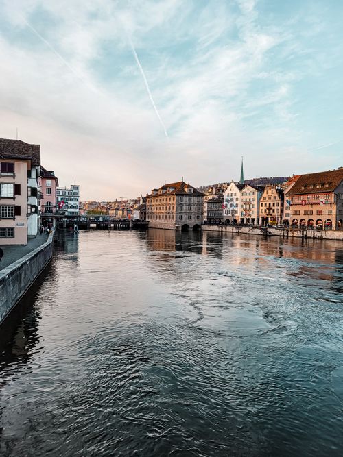 Free Tranquil scenic view of Zurich's historic waterfront with traditional European architecture at dusk. Stock Photo
