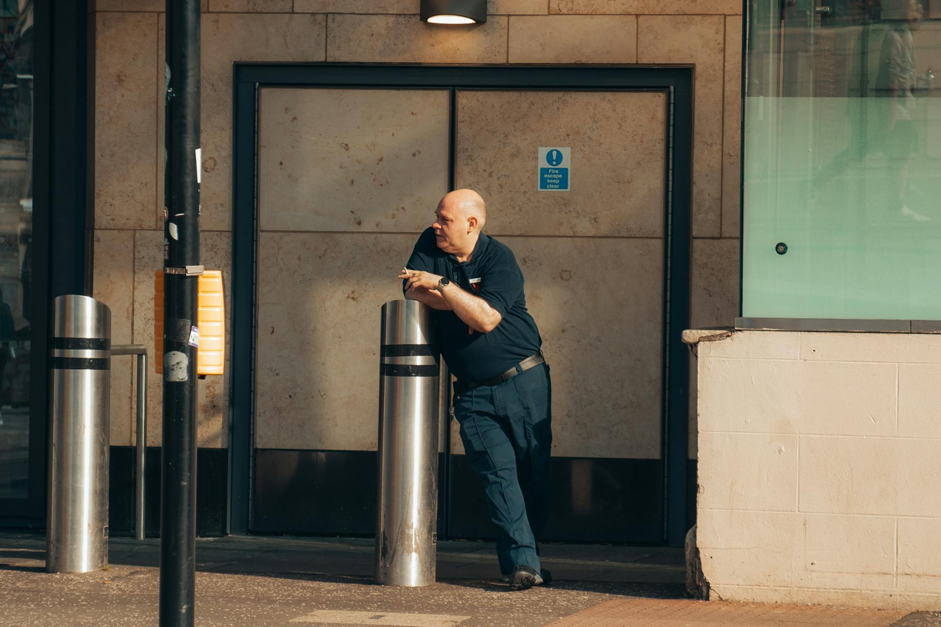 A security guard stands vigilantly outside a city building, emphasizing urban safety concepts.