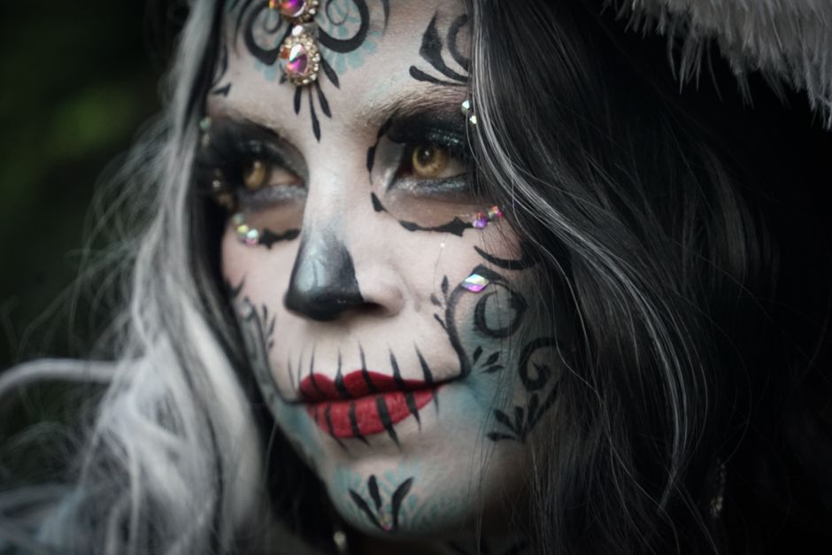 Artistic close-up portrait featuring Dia de los Muertos makeup with intricate details and vibrant colors.