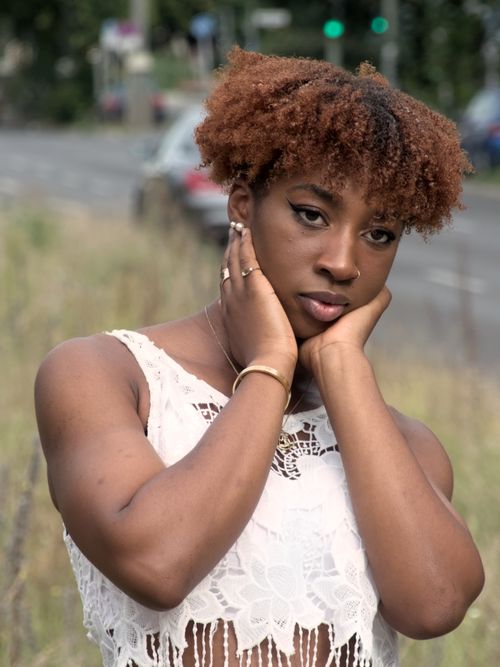 Free Captivating portrait of a young woman with a thoughtful expression, set in Berlin. Stock Photo