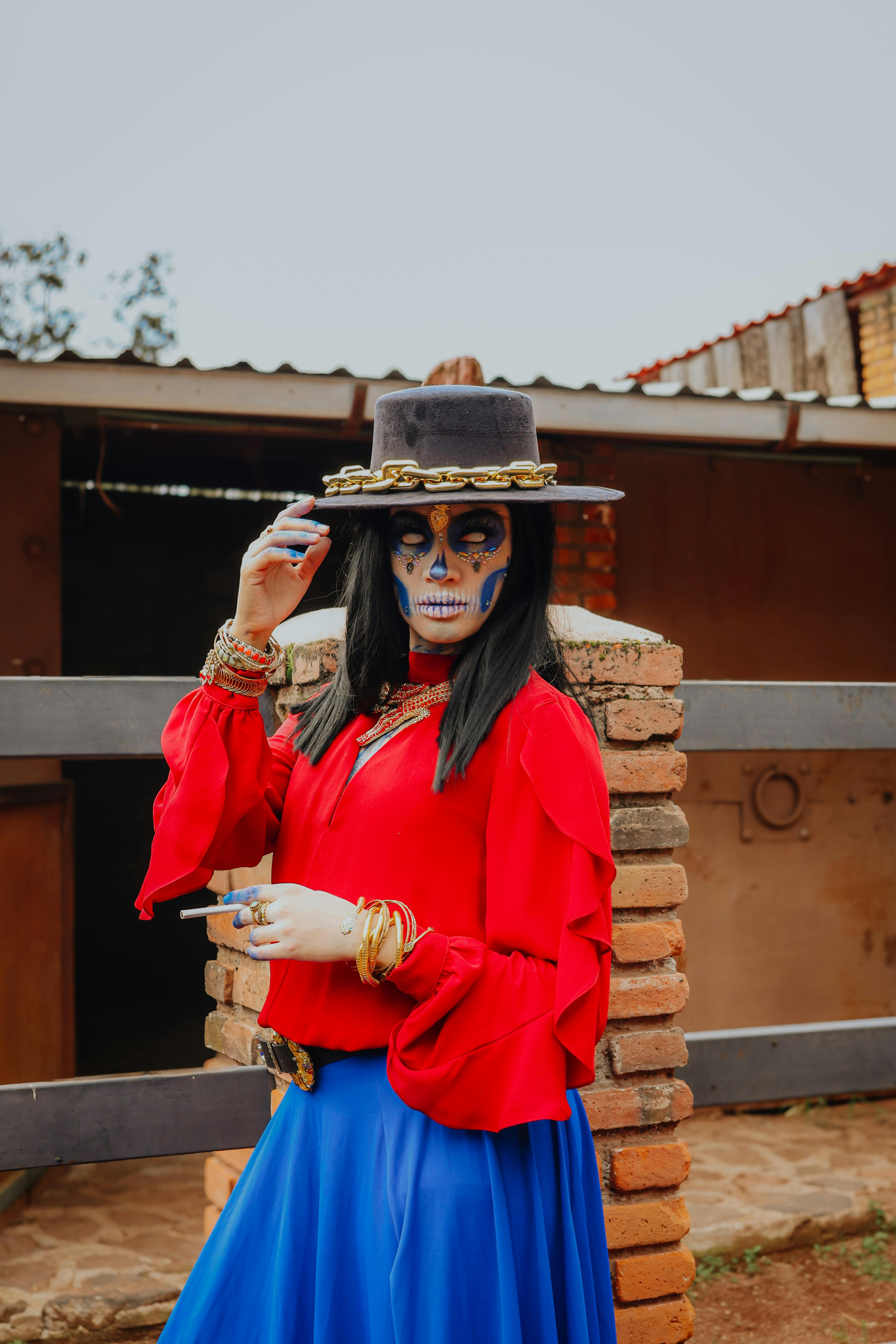 a woman in a blue skirt and red top with a hat