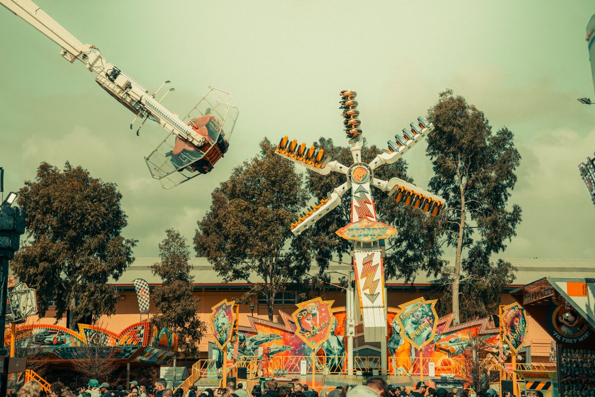 Vibrant carnival ride silhouetted against the open sky