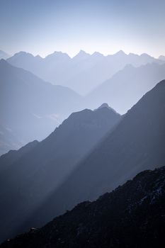 Breathtaking view of misty mountain layers at sunrise, showcasing serene natural beauty.