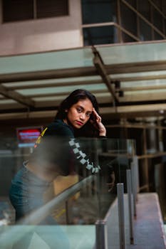 一位时尚的年轻女子在城市环境中摆出户外姿势，展现风格与自信