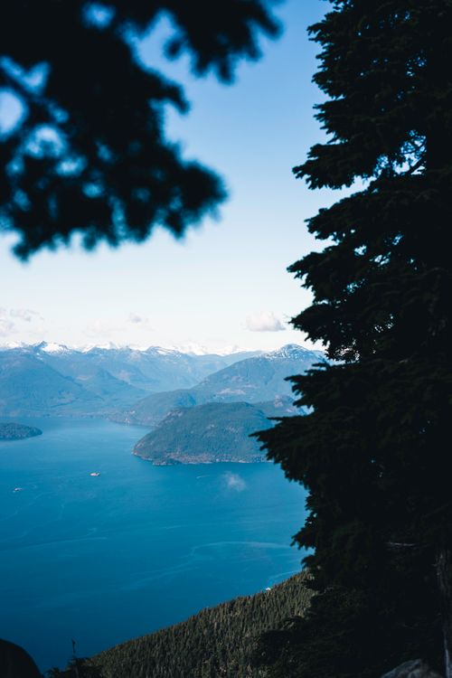 Free Stunning aerial perspective of Vancouver's mountainous and oceanic landscape with evergreen forests. Stock Photo