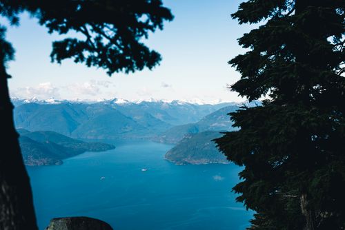 Free Stunning view of mountains and ocean from a forested area in Vancouver, Canada. Stock Photo