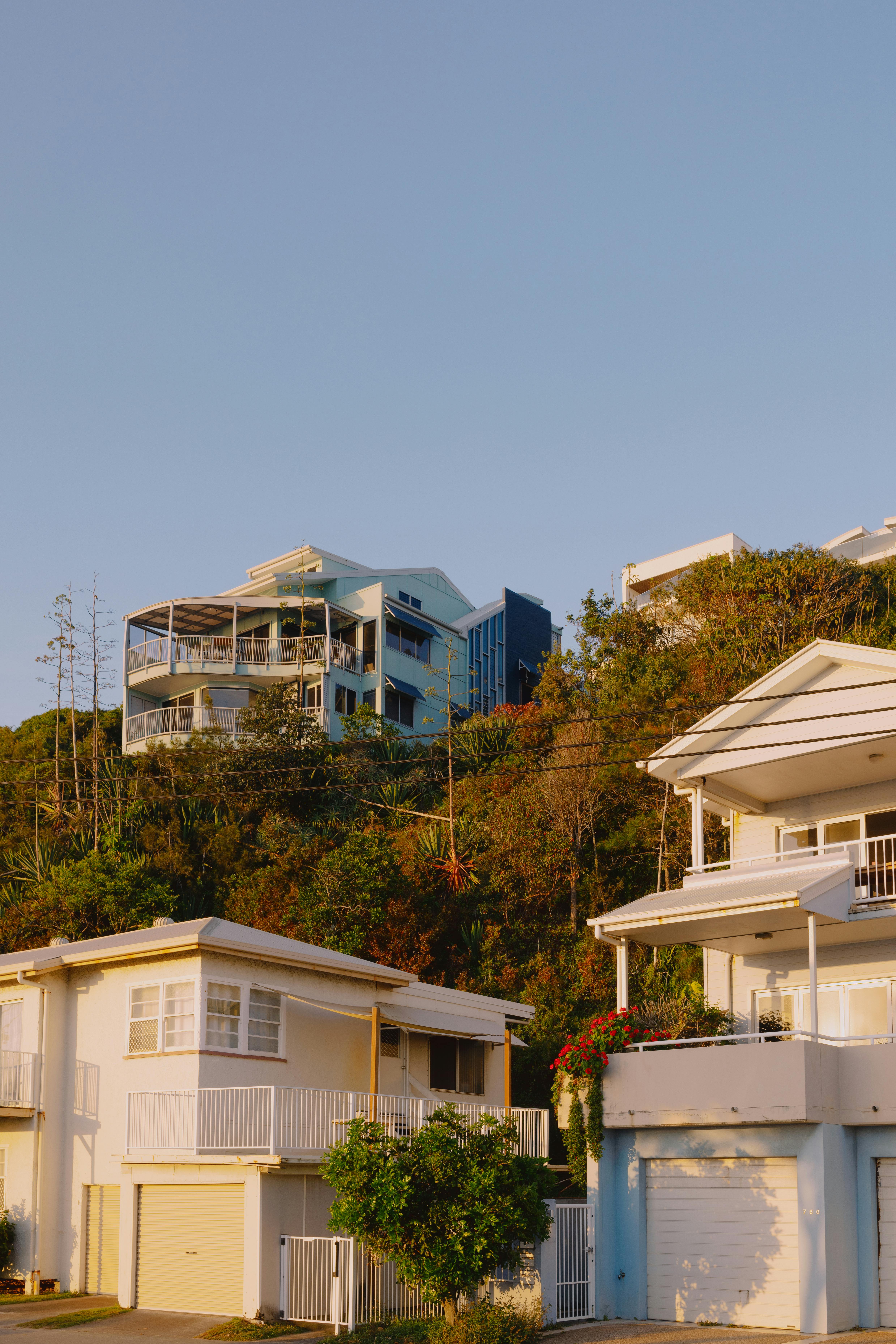 Hillside houses basking in golden hour sunlight in Currumbin, Australia.