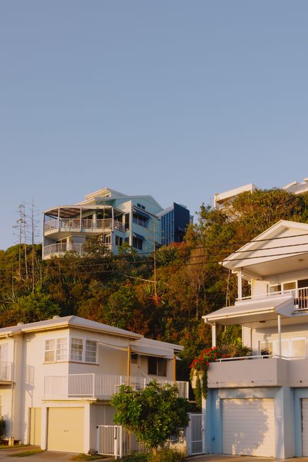 Hillside houses basking in golden hour sunlight in Currumbin, Australia.
