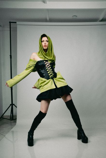Chic fashion photoshoot with model in stylish corset and headscarf ensemble.
