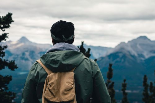 Free A man with a backpack enjoys the scenic mountain view in Banff National Park, Canada. Stock Photo