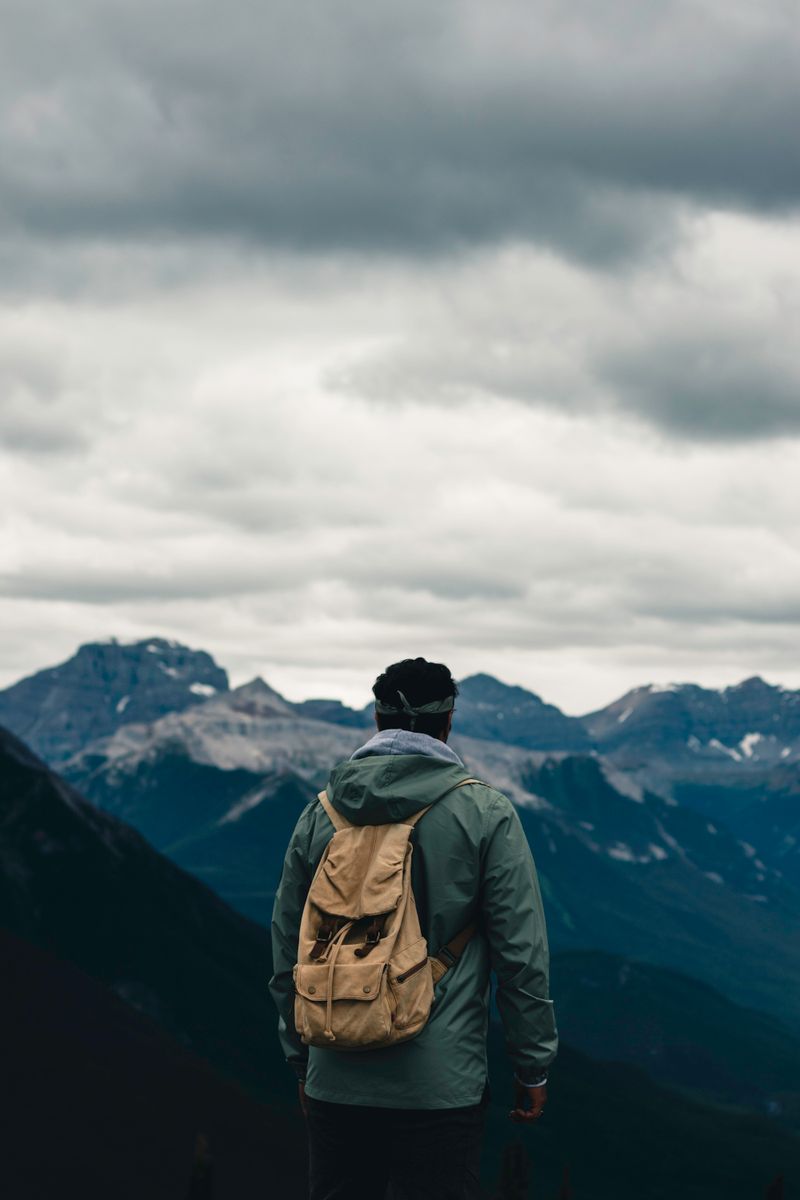 Man in Jacket and with Backpack Hiking in Forest · Free Stock Photo