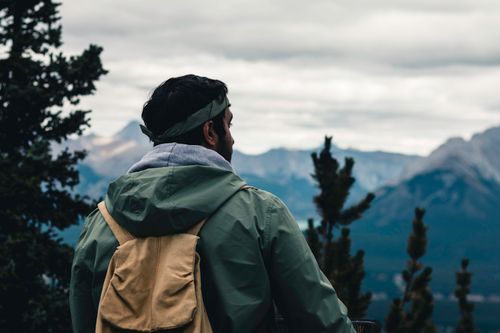 Free Back view of a man hiking with a backpack in Banff National Park, Alberta. Stock Photo