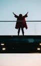 Back View Photo of Standing Woman with Her Hands Raised