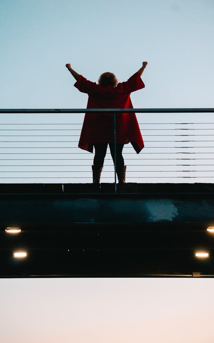 Back View Photo Of Standing Woman With Her Hands Raised