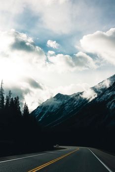 A stunning view of a winding road through the majestic mountains of Kootenay Crossing, British Columbia.