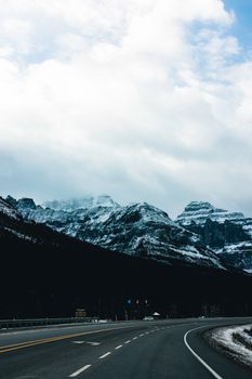 A winding highway through the snowy Rocky Mountains in Kootenay Crossing, BC, Canada.