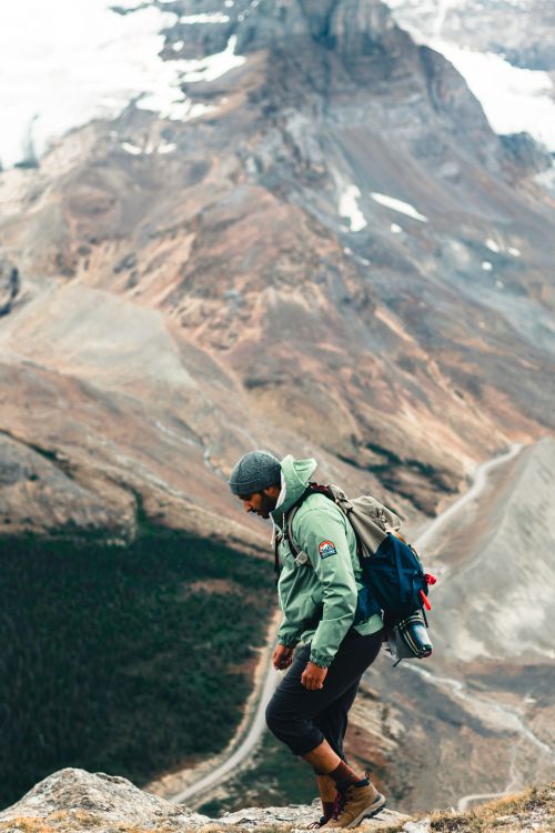Free Man hiking along a rugged mountain trail in Jasper, AB with scenic views. Stock Photo
