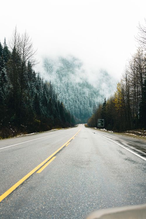 Free A foggy highway leading through mountains and forest in Glacier, BC, Canada. Stock Photo