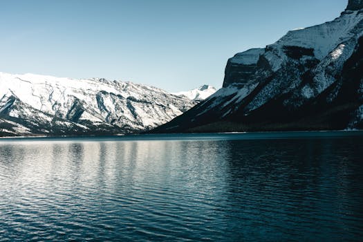 Breathtaking view of snowcapped mountains in Glacier, BC, Canada reflecting on a pristine lake.