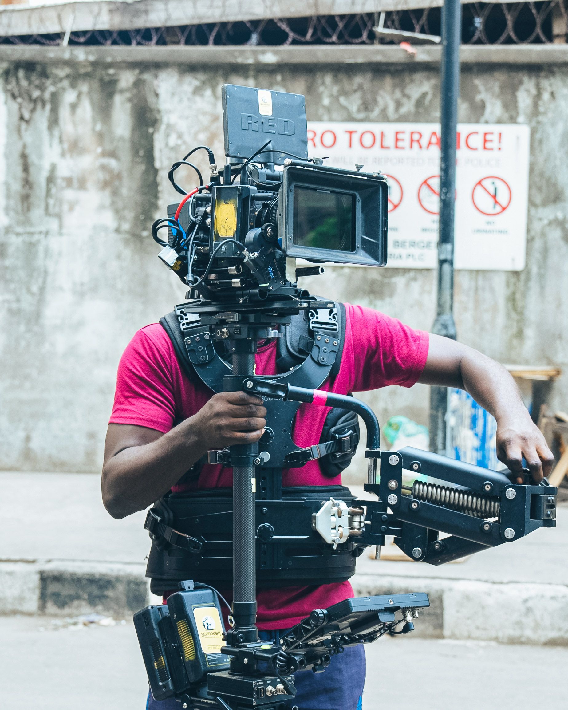 Professional cameraman using a gimbal rig on urban street for filming